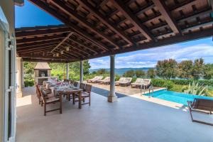 a patio with a table and chairs and a swimming pool at Villa Gumonca in Supetar