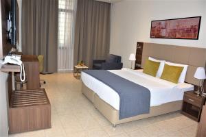 ジブチにあるCapital Hotel Djiboutiの大きなベッドと電話が備わるホテルルームです。