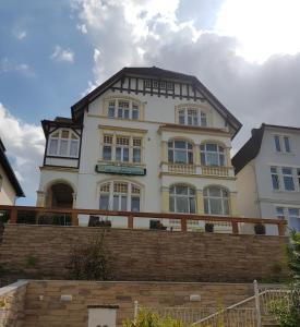 ein weißes Haus mit braunem Dach in der Unterkunft Villa zur schönen Aussicht in Bad Salzuflen