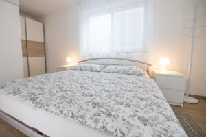 una camera bianca con un letto e due lampade di Sobe Meta a Brezje