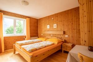um quarto com uma cama num quarto com paredes de madeira em Ferienhaus Zech em Marul