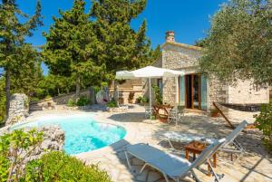 a stone house with a swimming pool and a patio at Villa Gallini in Vlachopoulátika