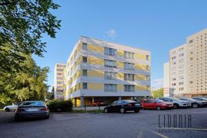 een hoog gebouw met auto's geparkeerd op een parkeerplaats bij Sunny Studio with Parking, Self-Check-In & Wi-Fi in Tallinn