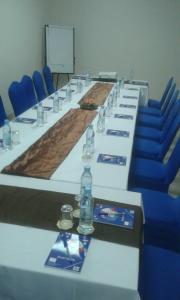 - une grande table avec des chaises bleues et des bouteilles d'eau dans l'établissement Capital Hotel Djibouti, à Djibouti