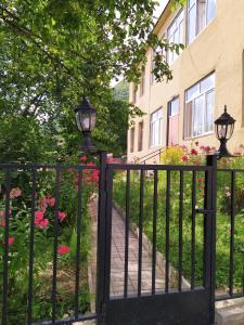 a black iron gate with a sidewalk and flowers at Guesthouse Lenjeri in Mestia