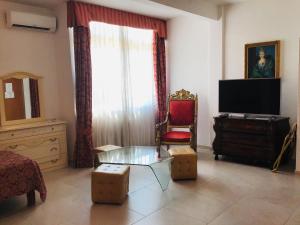 a living room with a glass coffee table and a television at Hotel Giulietta e Romeo in Casal Palocco