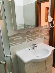 La salle de bains est pourvue d'un lavabo et d'un miroir. dans l'établissement Hotel Giulietta e Romeo, à Casal Palocco