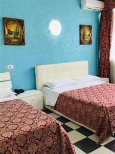 a room with two beds and a blue wall at Hotel Giulietta e Romeo in Casal Palocco
