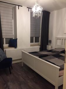 Un dormitorio con una cama grande y una lámpara de araña. en Zimmer 1, en Erfurt