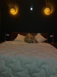 - une chambre avec un grand lit blanc et deux lumières dans l'établissement Diane Luxury 1, à Roubaix