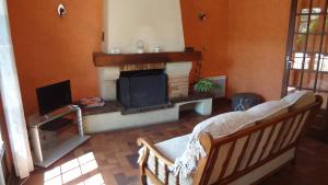 un soggiorno con camino e TV di Maison de vacances a Trévières