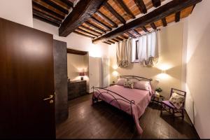 Schlafzimmer mit einem Bett mit rosa Tagesdecke in der Unterkunft Appartamento Da Lucia in Città della Pieve