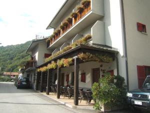 a building with tables and chairs on a street at Hotel Berlinghera in Sorico