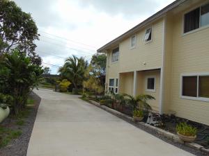 a sidewalk in front of a house with plants at Coco-nut Hale in Kailua-Kona