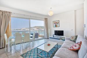 ein Wohnzimmer mit einem Sofa und einem Tisch in der Unterkunft HV12 - Sea Front Penthouse in St Paul's Bay