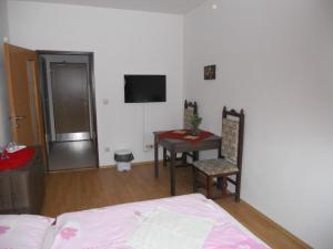 a bedroom with a bed and a table and a television at Motel Madona in Banská Bystrica