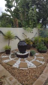 un jardín con un jarrón y una fuente en el medio en Angel's Corner en Ciudad del Cabo