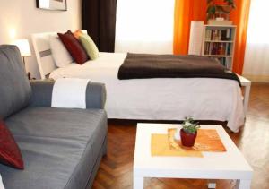 1 dormitorio con cama, sofá y mesa en Cosy Appartement close to City, en Viena