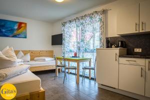 a room with a bed and a table and a kitchen at Gita´s Haus in Rust