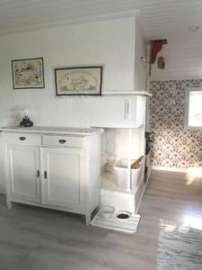 a white bathroom with a toilet in a room at Unikt läge med stora Alvaret som närmsta granne in Mörbylånga