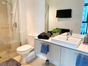 um banheiro com pia, vaso sanitário e chuveiro em Large 2B2B Near Southern Cross FreeParking GYM POOL em Melbourne