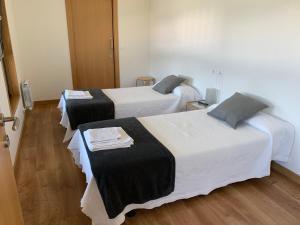 Habitación con 2 camas y sábanas blancas y negras. en Linar Do Rei, en Linares