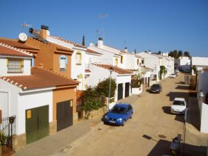 una calle con casas y un coche azul estacionado en la calle en Ayamonte Mirador, en Ayamonte