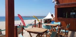 a beach with tables and chairs and a person on the beach at Cabedelo guest house in Viana do Castelo