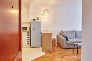 a small kitchen with a refrigerator and a couch at Estudio nuevo centro de Vigo in Vigo