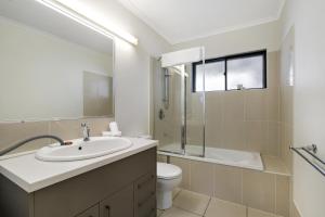 a bathroom with a sink and a toilet and a shower at Family-Size Duplex in Quiet Neighbourhood in Brisbane