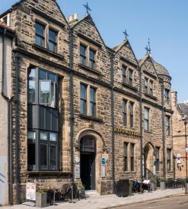 an old stone building on the corner of a street at Kinnettles Hotel & Spa in St Andrews