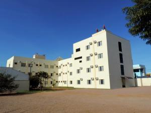 a large white building with aventh floor at Hotel Pequeno Mundo 2 in Campo Verde