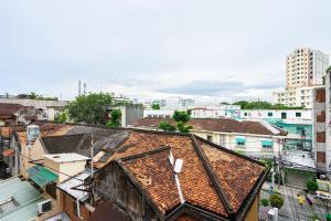 een uitzicht over de daken van gebouwen in een stad bij Maison Royale in Ho Chi Minh-stad
