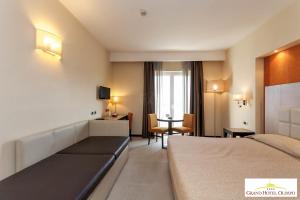 a hotel room with a bed and a desk at Grand Hotel Olimpo in Alberobello