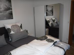 ein Schlafzimmer mit einem Bett mit Kissen und einem Spiegel in der Unterkunft Ferienwohnung Mondfänger in Wüstensachsen