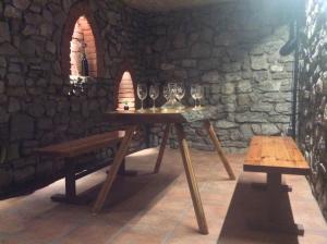 a table with wine glasses on it in a stone room at Vinný sklípek Na Spojovací in Mutěnice