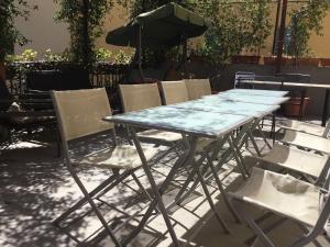 einen Tisch mit Stühlen und einem Sonnenschirm auf einer Terrasse in der Unterkunft New Hostel Florence in Florenz