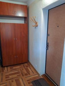 Zimmer mit einem Schrank und einer Tür mit einem Hirschkopf an der Wand in der Unterkunft Apartment on Livoberezna metro station in Kiew