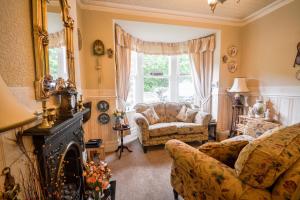 a living room with a couch and a fireplace at Gorphwysfa House B & B in Betws-y-coed