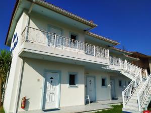 a white building with a balcony on the side at Makinia Beach in Nafpaktos