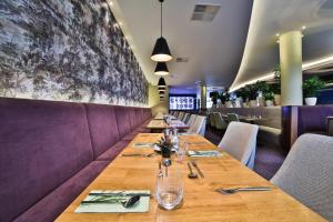 a long table in a restaurant with purple booths at Botanique Hotel Prague in Prague
