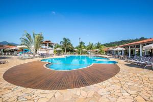 una piscina en un complejo con sillas y mesas en Hotel Fazenda Hípica Atibaia, en Atibaia