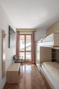 een slaapkamer met een stapelbed en een stoel bij ARTEFUGIUM panoramico in Selva di Val Gardena