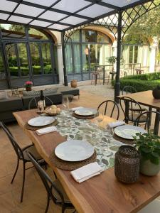 a wooden table with plates and glasses on it at Hotel Il Gelso in Pontevico