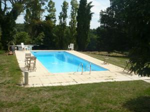 una piscina en un patio con sillas y mesa en Les Convertigues, en Montjoire