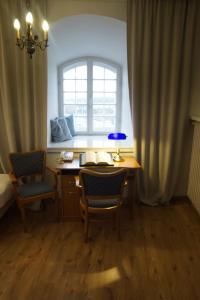 a room with a desk with two chairs and a window at Pokoje Gościnne Dom Literatury in Warsaw