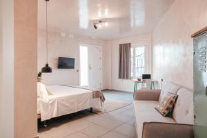 een slaapkamer met een bed en een bank in een kamer bij Astuto Boutique Jerez - Adults Only in Jerez de la Frontera