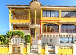 żółty budynek ze schodami przed nim w obiekcie Appartement BlancoSol in La Mata w mieście Torrevieja