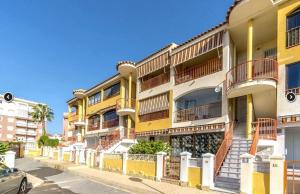 rząd żółtych budynków apartamentowych na ulicy w obiekcie Appartement BlancoSol in La Mata w mieście Torrevieja