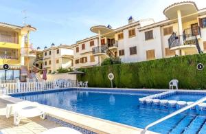 basen przed kilkoma budynkami mieszkalnymi w obiekcie Appartement BlancoSol in La Mata w mieście Torrevieja